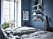 Sovrum med blåa väggar, vägghylla och ljusblåa textilier