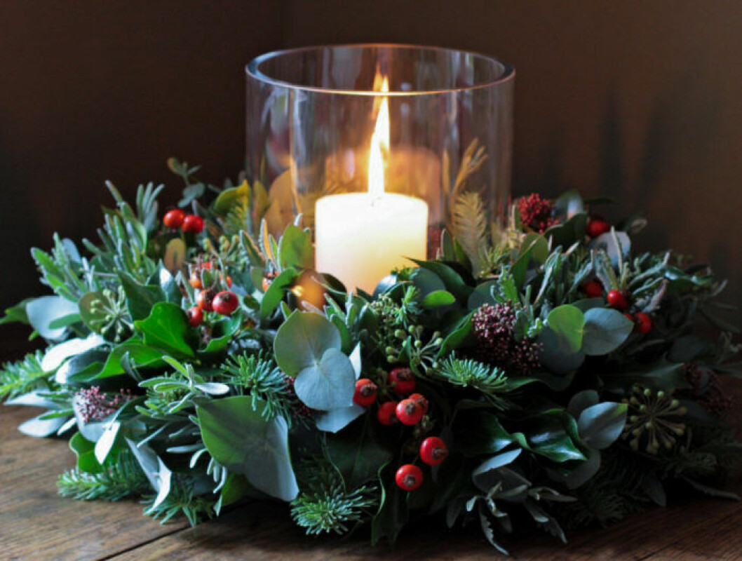 Foto: The flower school Julkrans placerad runt rund ljuslykta.