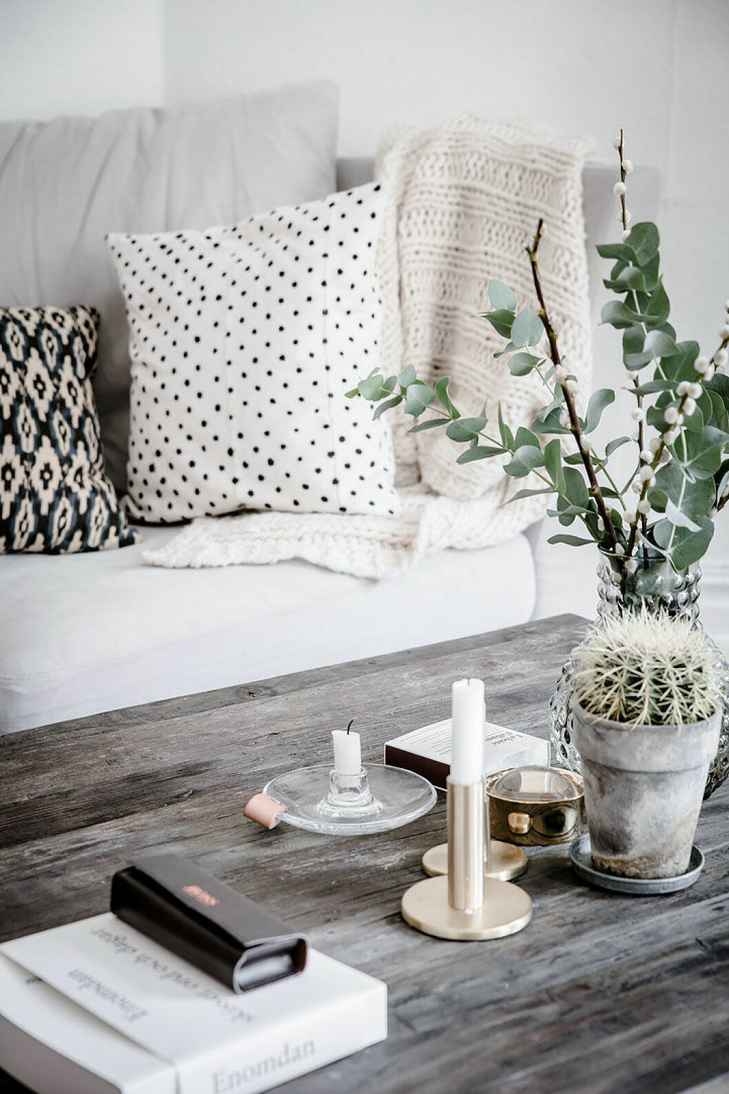 Foto: Anders Bergstedt och Fredrik J Karlsson Styling: Studio Cuvier för <a href="https://www.instagram.com/alvhem/" target="_blank" rel="noopener">Alvhem</a>/mäklare: Sandra Guerrero Vide och eukalyptuskvistar i en vas på ett vardagsrumsbord