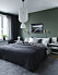 Sovrum med gröna väggar och lyxig matta att sätta ned fötterna på