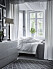 Cosy bedroom with grey and white colours. Fabric over the bed. Scandinavian interior decoration ideas and inspiration. 