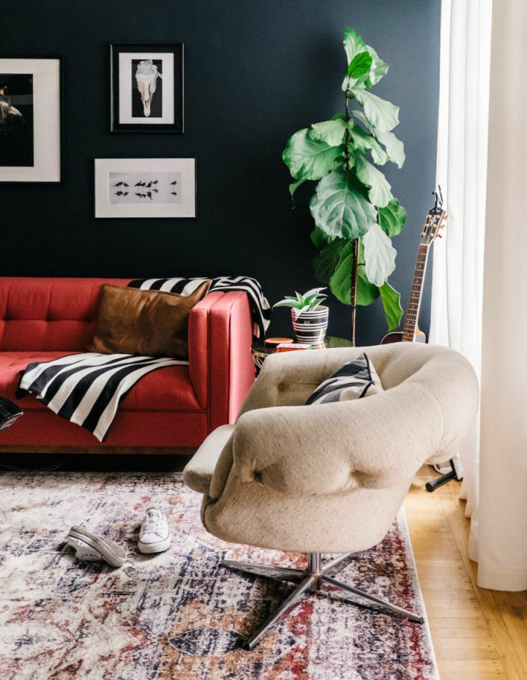 Foto: <a href="http://theeverygirl.com/dj-blue-this-san-francisco-living-room-gets-a-makeover/" target="_blank" rel="noopener">The every girl</a> En röd soffa.