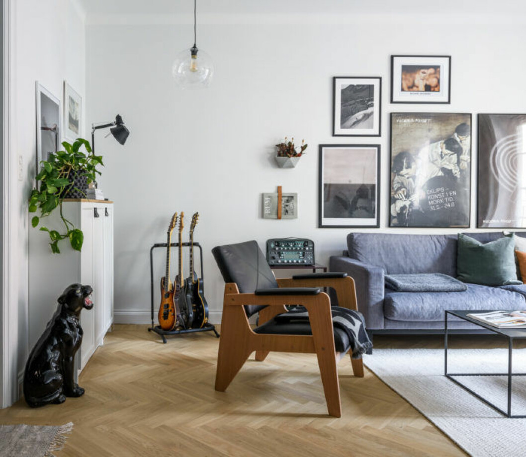 Foto: Peo Bengtsson Styling: Terese Hofverberg Ahl för <a href="https://www.instagram.com/bjurfors_stockholm/" target="_blank" rel="noopener">Bjurfors</a>/mäklare: Ellen Ingman och Frida Edsmar Vardagsrum med prydnadspanter, stol i läder och trä och blå soffa. Tavelvägg och gröna växter.