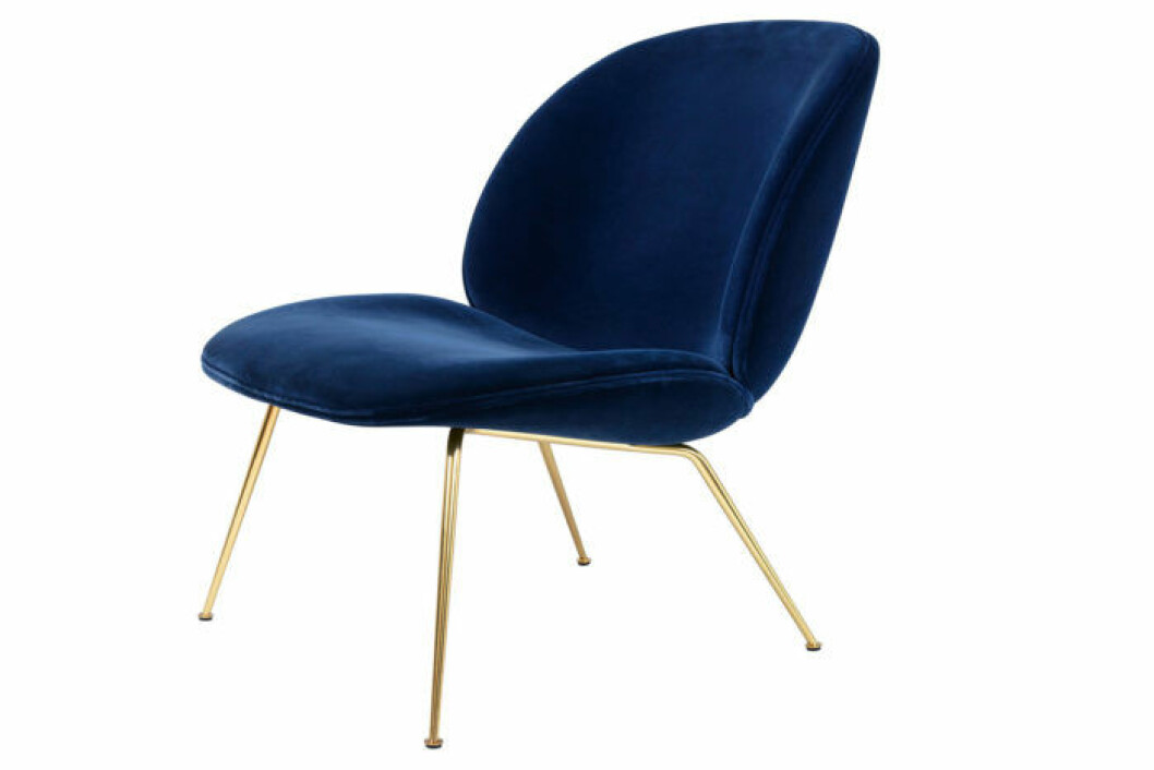 Loungestol i mörkblå sammet och med ben i mässin