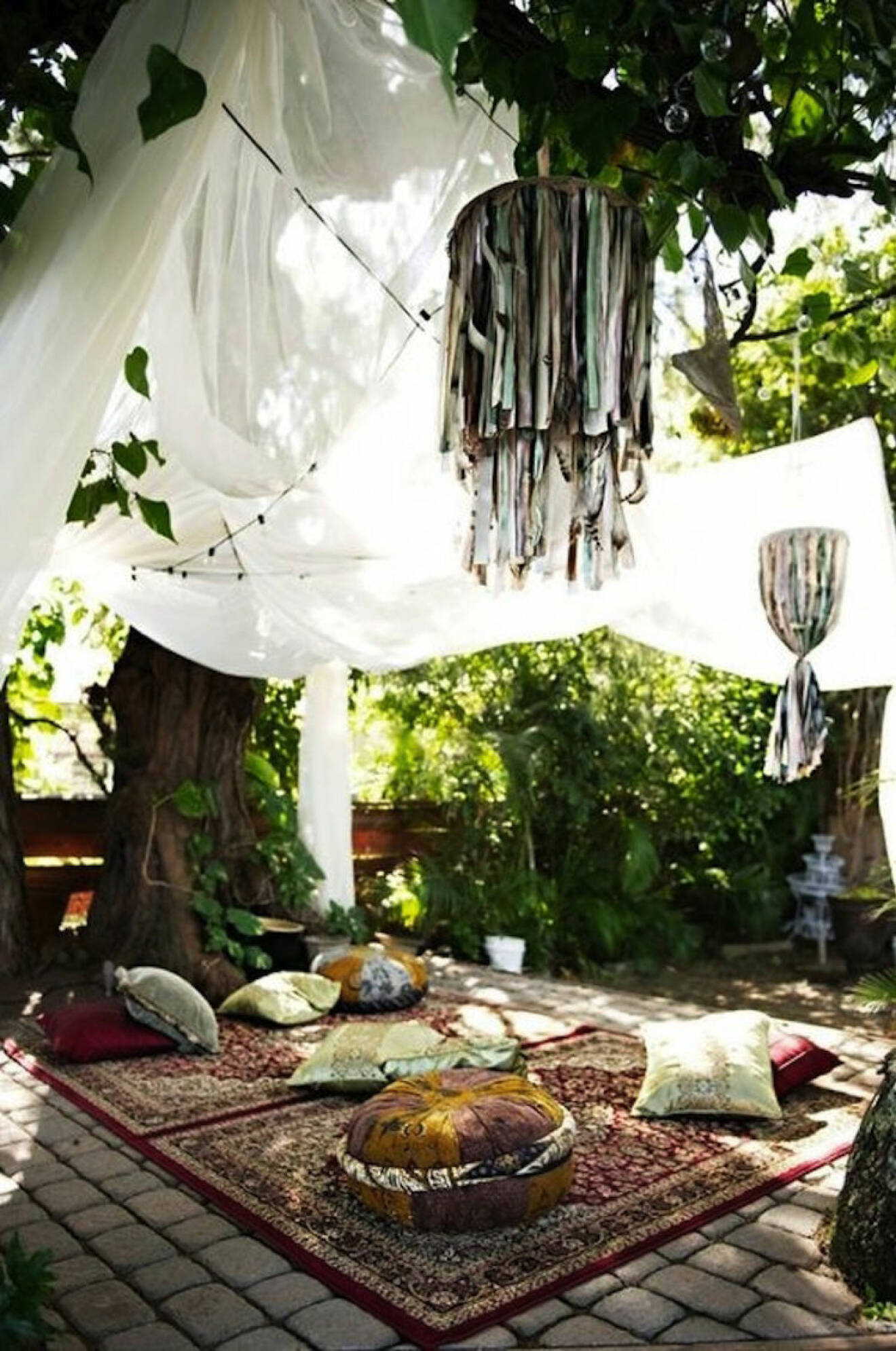 Pyntad trädgård med stora textilier i träden
