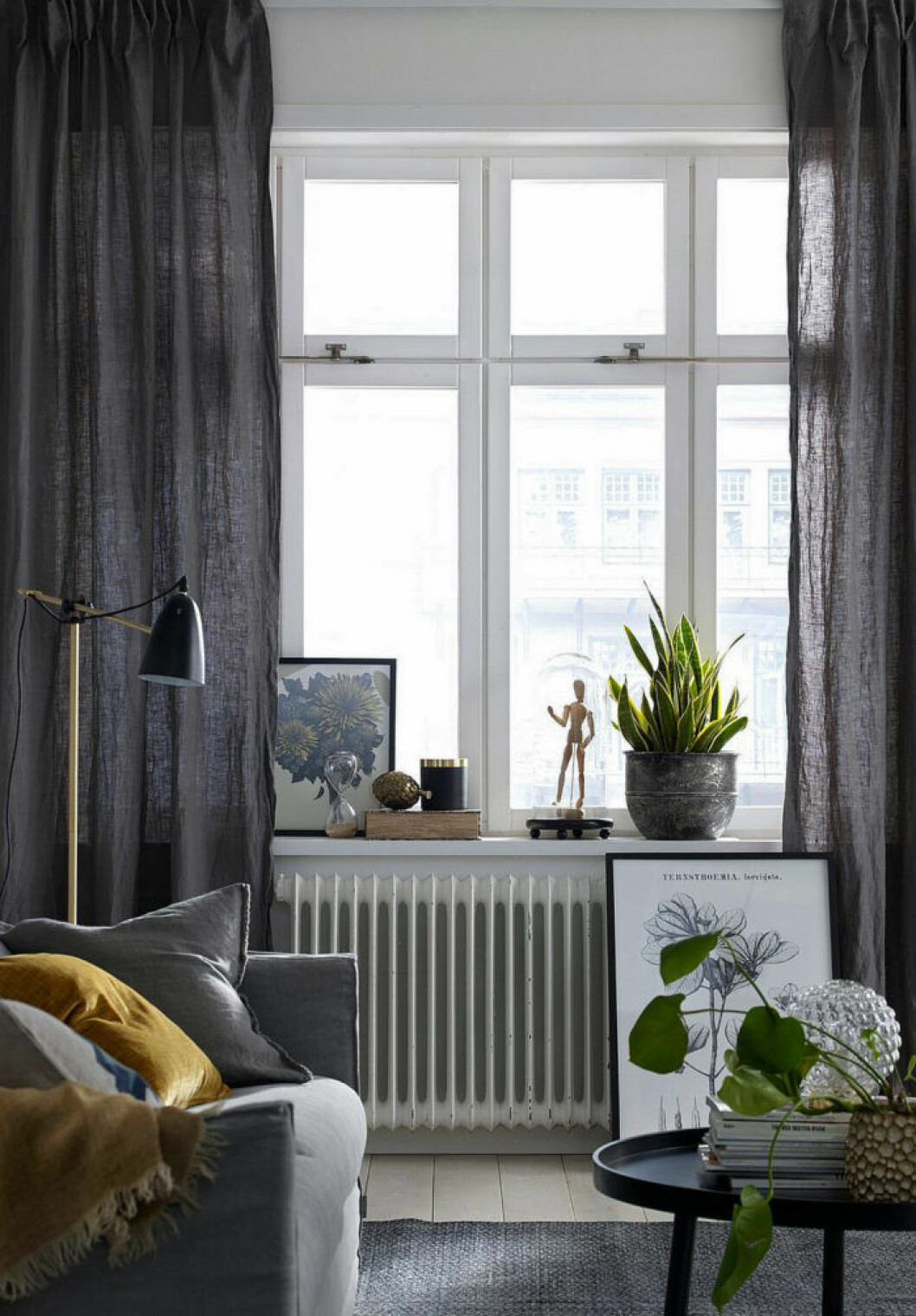 Linnegardiner är undantaget från regeln och kan vara fina både strukna och ostrukna. Foto: Ellos home Mörkgråa gardiner som ramar in fönstret