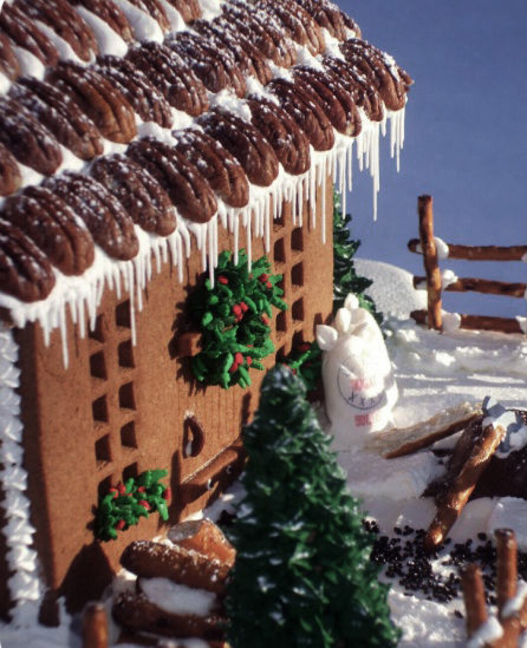 Foto: <a href="http://sweetopia.net/2009/03/gingerbread-woodcutters-cabin/" target="_blank" rel="noopener">Sweetopia</a> Pekannötter som takplattor på pepparkakshus.