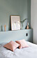 Sovrum med mintgröna väggar och rosa kuddar