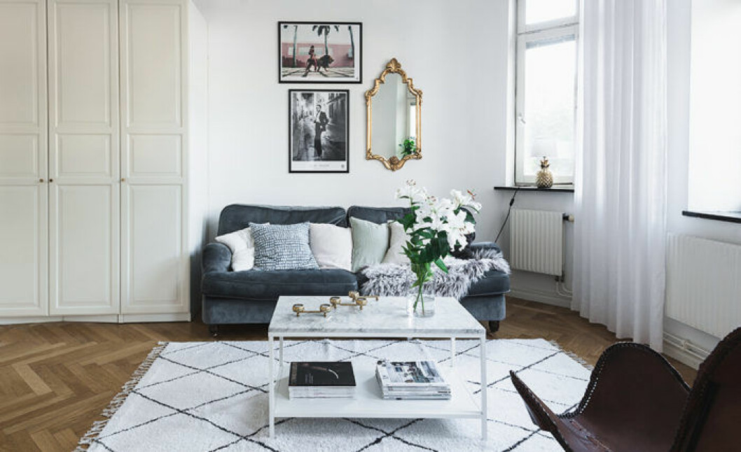 Foto: Mika Aberra för <a href="https://www.instagram.com/entrancemakleri/" target="_blank" rel="noopener">Entrance mäkleri</a>/mäklare: Jonathan Liljegren Guldspegel i barockstil bakom soffan i vardagsrummet.