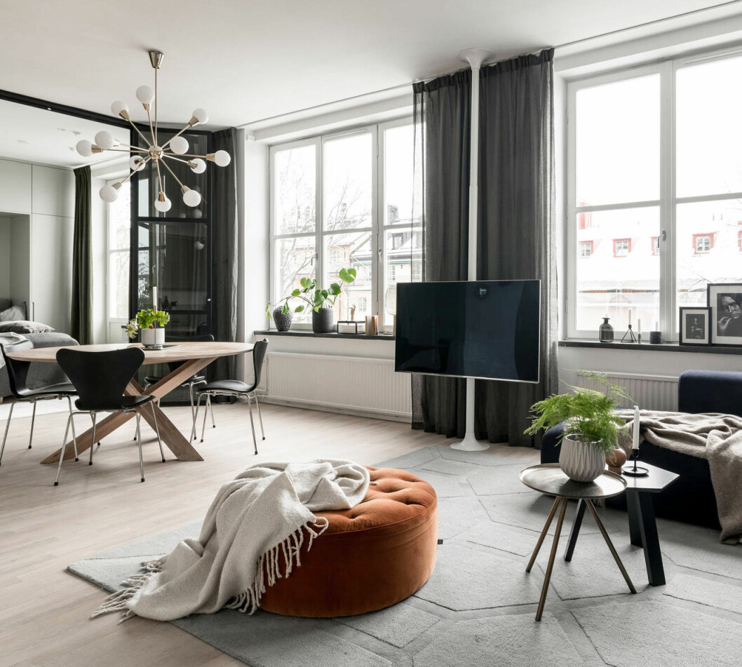 Foto: Marcus Stork Styling: Scandinavian Homes för <a href="https://www.instagram.com/alexanderwhitesthlm/" target="_blank" rel="noopener">Alexander White</a>/mäklare: Johan Franzon Vardagsrum med sittpuff och taklampa med mässingsdetaljer. Fjädersparris i kruka.