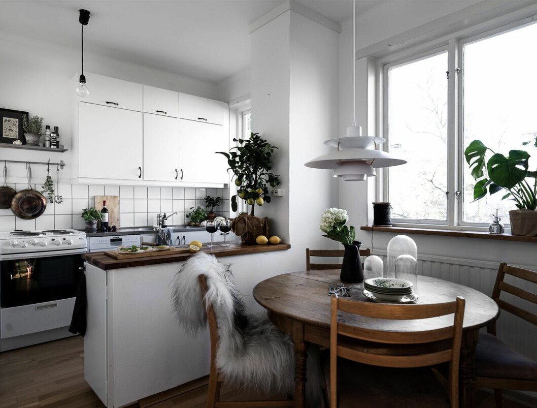 Foto: Johan Spinnell Styling: Jennie Edvinsson för<a href="https://www.instagram.com/historiskahem/" target="_blank" rel="noopener"> Historiska hem</a>/mäklare: Mattias Lantto Kök med ljusa luckor och ett runt bord i mörkt trä