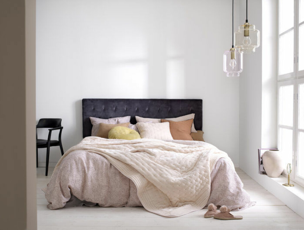 Sovrum med rosa bäddning och stoppad sänggavel i mörklila nyans. Våren 2018 på Ellos Home.