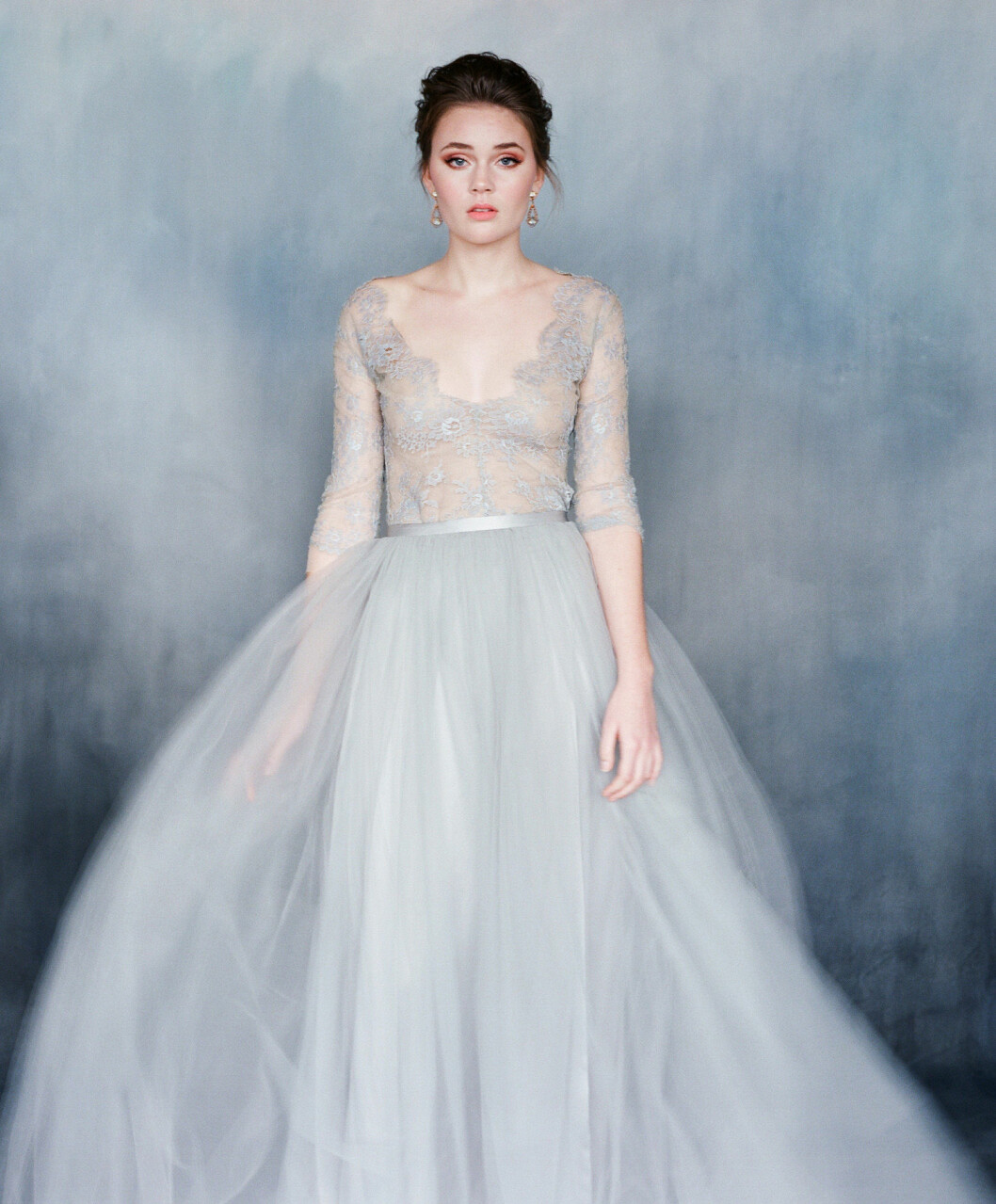 Foto: <a href="https://www.emilyriggsbridal.com/collections/gowns/products/nightingale" target="_blank" rel="noopener">Emily Riggs</a> Ljusgrå bröllopsklänning med tyll och spets