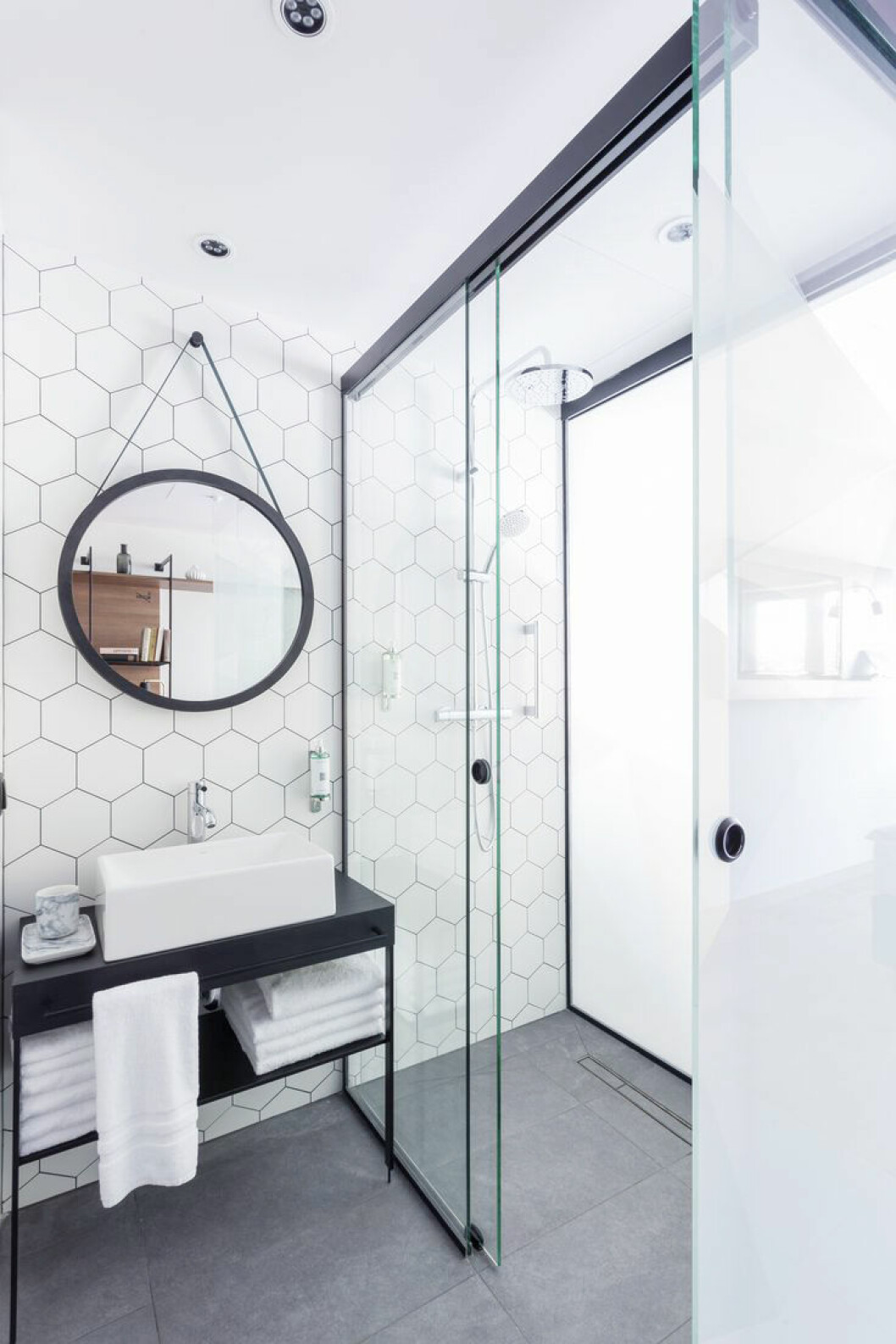 Via: Deco Uvrir Design Stilrent badrum med gråa klinkerplattor och hexagonmönstrade, vita plattor på väggarna.
