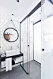 Stilrent badrum med gråa klinkerplattor och hexagonmönstrade, vita plattor på väggarna.