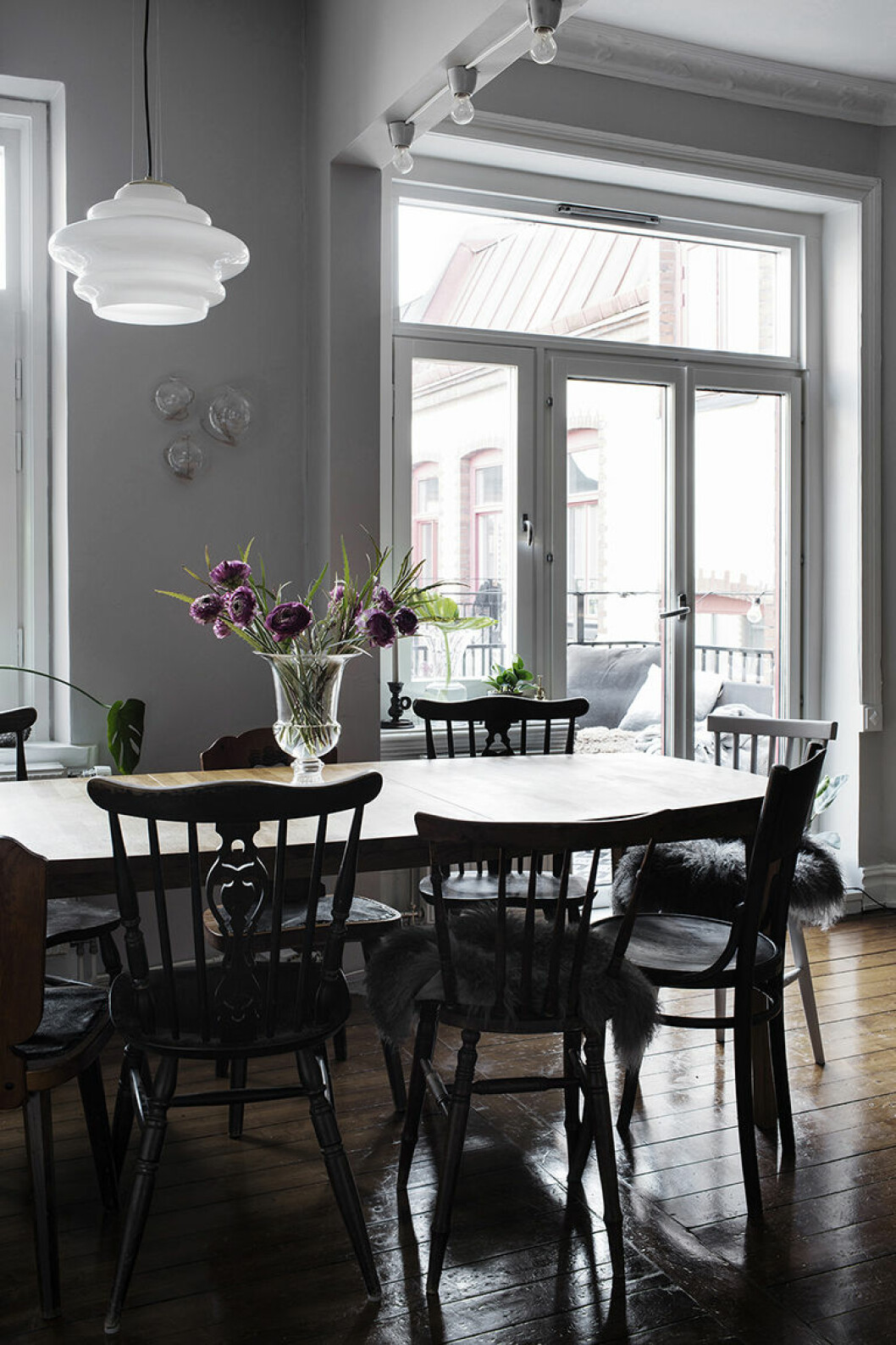 Matplats med rustika stolar runt och en bukett på bordet