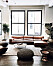 Svarta fönster mot en cognacfärgad soffa