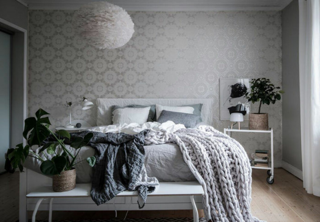 Foto: <a href="https://www.instagram.com/fotografalencordic/" target="_blank" rel="noopener">Alen Cordic</a> Styling: <a href="https://www.instagram.com/styledbyemmahos/" target="_blank" rel="noopener">Emma Fischer</a> för <a href="https://www.instagram.com/bjurfors_goteborg/" target="_blank" rel="noopener">Bjurfors</a>/mäklare: Charlotta Lenhammar. Mysigt sovrum med grovstickad filt, monstera och rund taklampa med fjädrar från Vita.