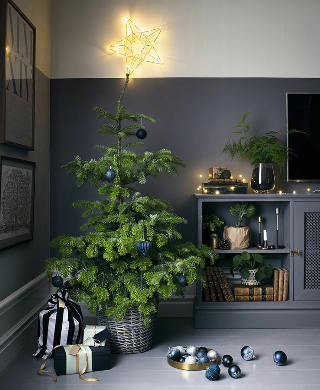 Foto: <a href="https://www.plantagen.se/" target="_blank" rel="noopener">Plantagen</a> Julgran med blå julgranskulor och lysande toppstjärna.