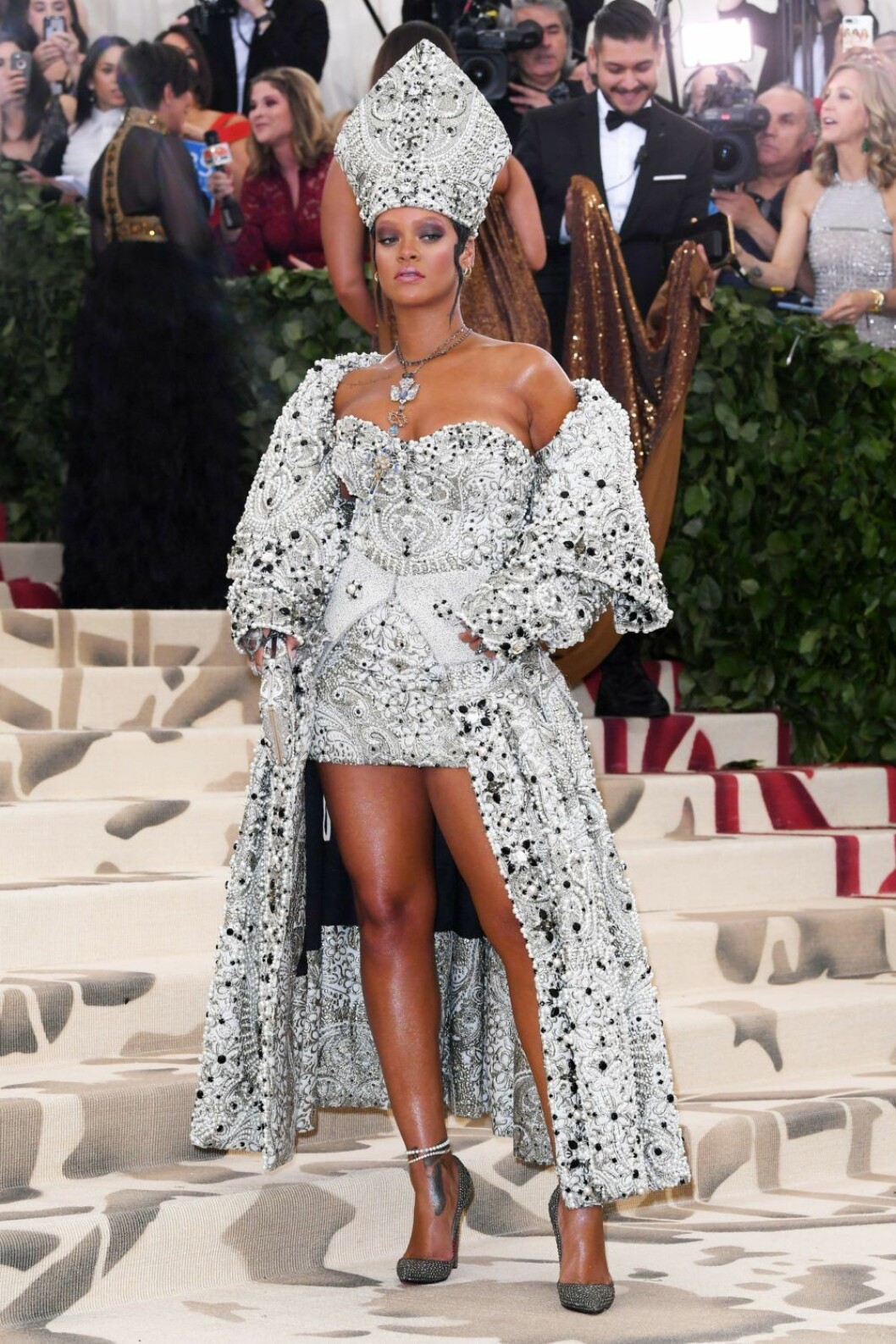 Rihanna i silvrig kort klänning med strass och huvudbonad.