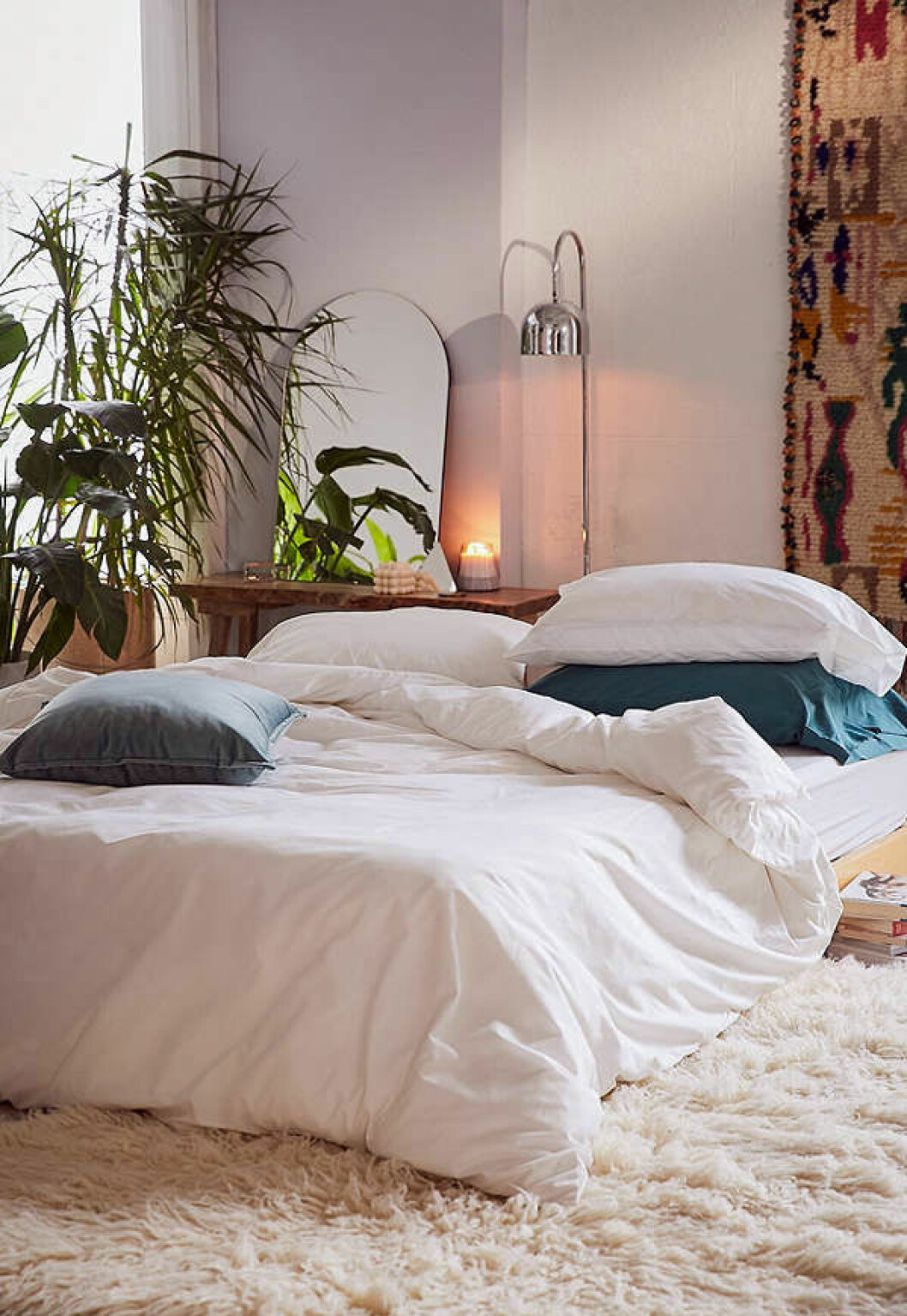 Foto: <a href="https://www.urbanoutfitters.com/shop/classic-percale-duvet-cover?category=bedding&color=010" target="_blank" rel="noopener">Urban outfitters</a> Vit säng i ombonad omgivning med växter och textilier