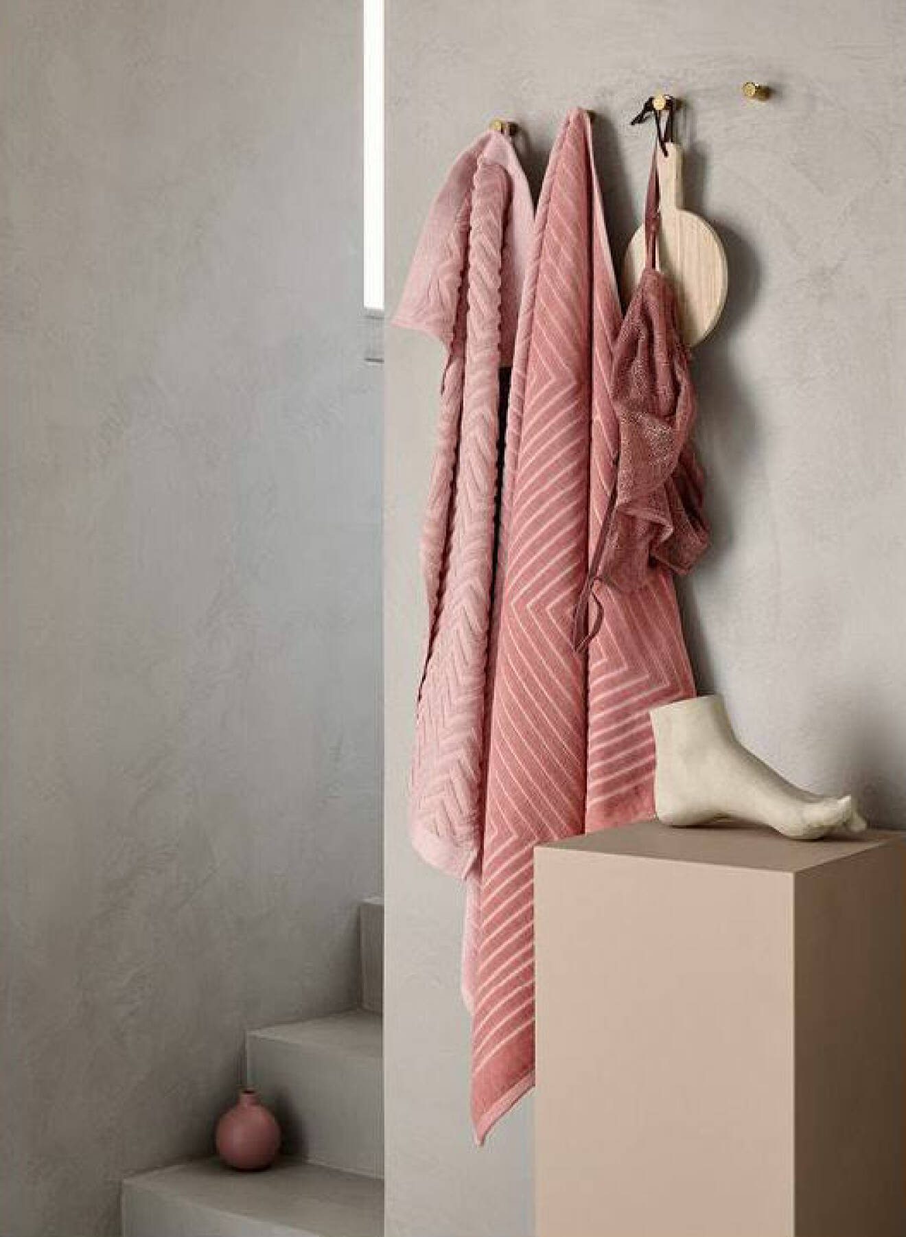 Rosa handdukar, badrum i betong och grått. Pidestal med prydnadsfot på. H&M Home våren 2018. 
