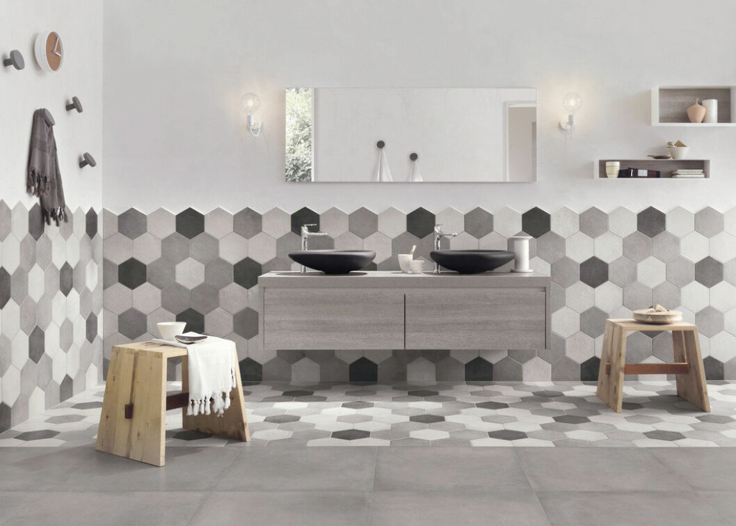 Via: Ragno Hexagonformat kakel i olika nyanser av grått i ett badrum.