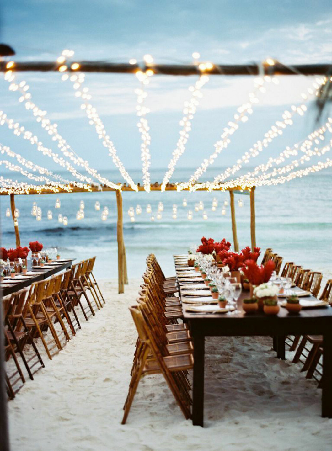 Foto: <a href="http://www.townandcountrymag.com/the-scene/weddings/news/a3511/paradise-found/" target="_blank" rel="noopener">Town and country</a> Strandbröllop vid havet, ljus sand och ljusslingor.