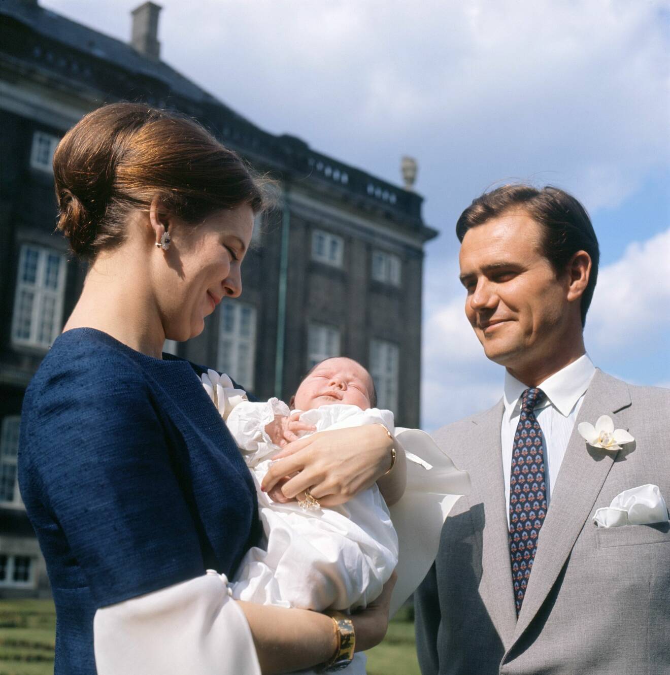 Drottning Margrethe och prins Henrik med en nyfödd prins Frederik i famnen.