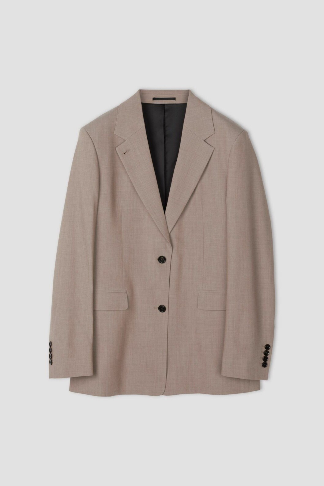Beige kavaj i större modell med svarta enkla knappar från Filippa K.