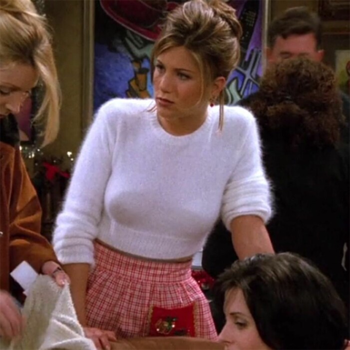 Rachel Green i en vit stickad tröja med en rosa kjol
