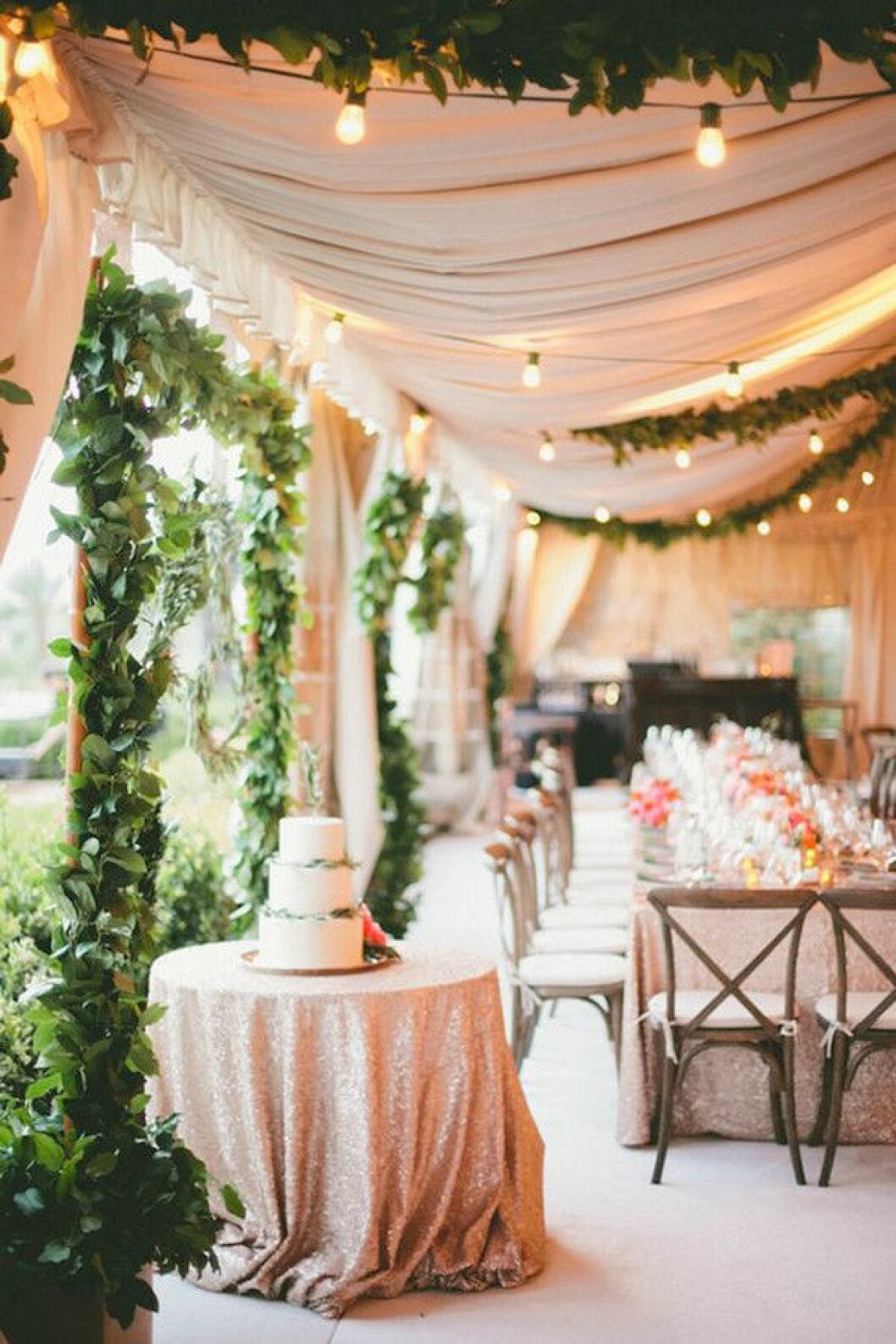 Foto via: <a href="http://www.deerpearlflowers.com/wedding-tent-decoration-ideas/glam-desert-wedding-reception-decor/" target="_blank" rel="noopener">Deer pearl flowers</a> Bröllopsmiddag, bröllopslokal med rosa tyger, ljusslingor och gröna växter som dekoration.