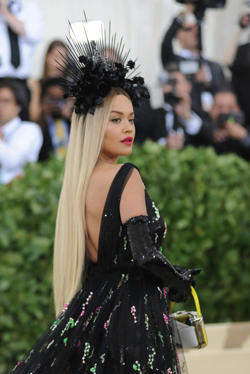 Rita Ora i svart klänning och maffig huvudbonad.