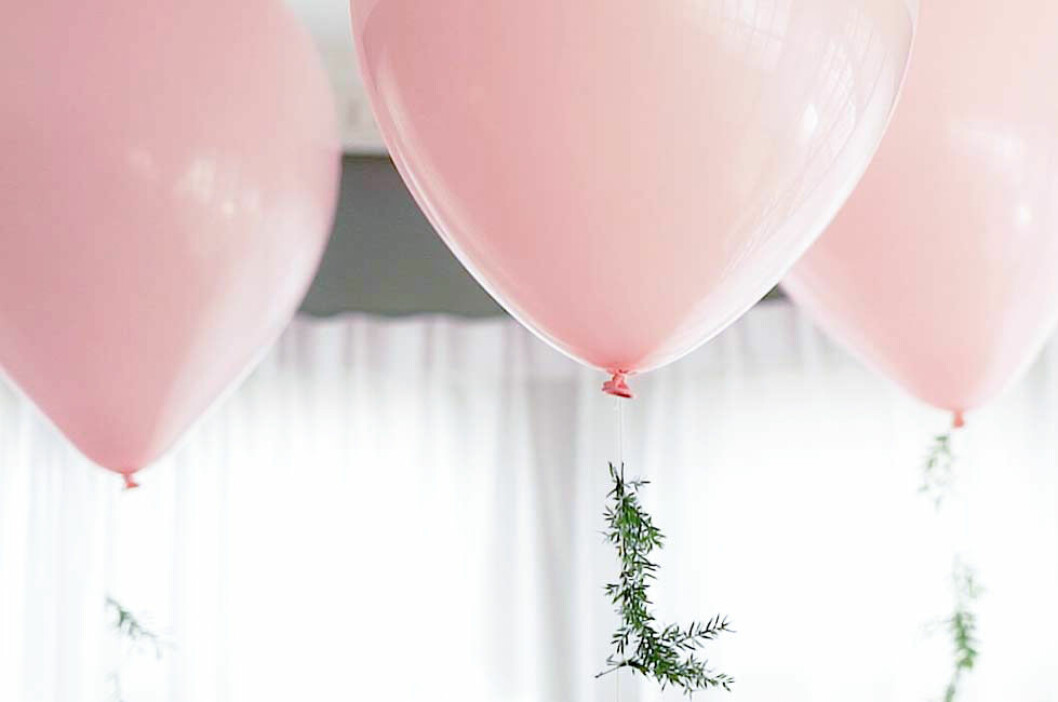 Ljusrosa ballonger med växter på