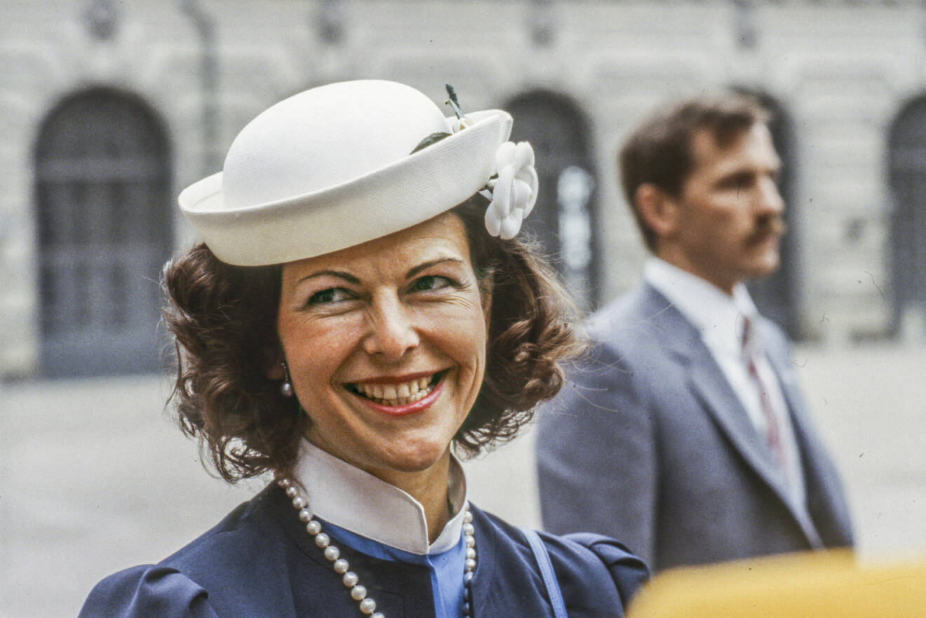 Drottning Silvia i blå kavaj och vit hatt.