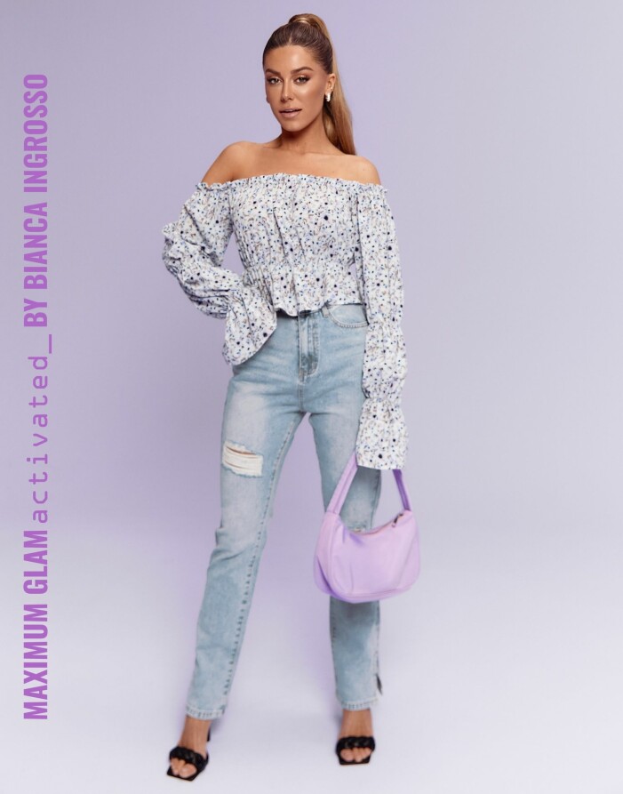 Bianca i en vårig outfit med blommig singoallatopp, ljusa jeans och svarta flätade klackar.