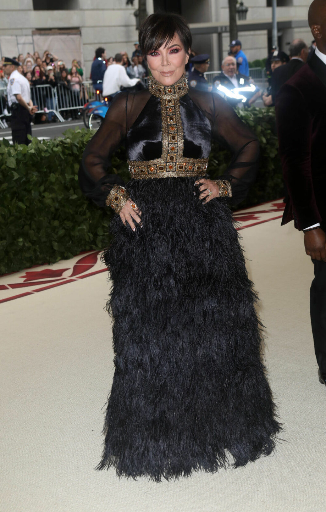 Kris Jenner i svart fjäderklänning.