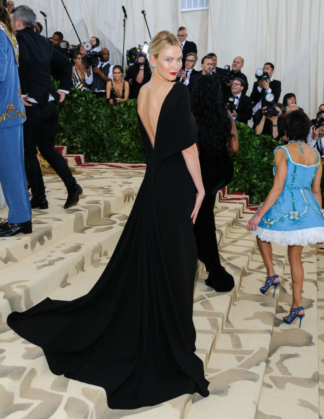 Karlie Kloss i långklänning med djup ryggurringning.