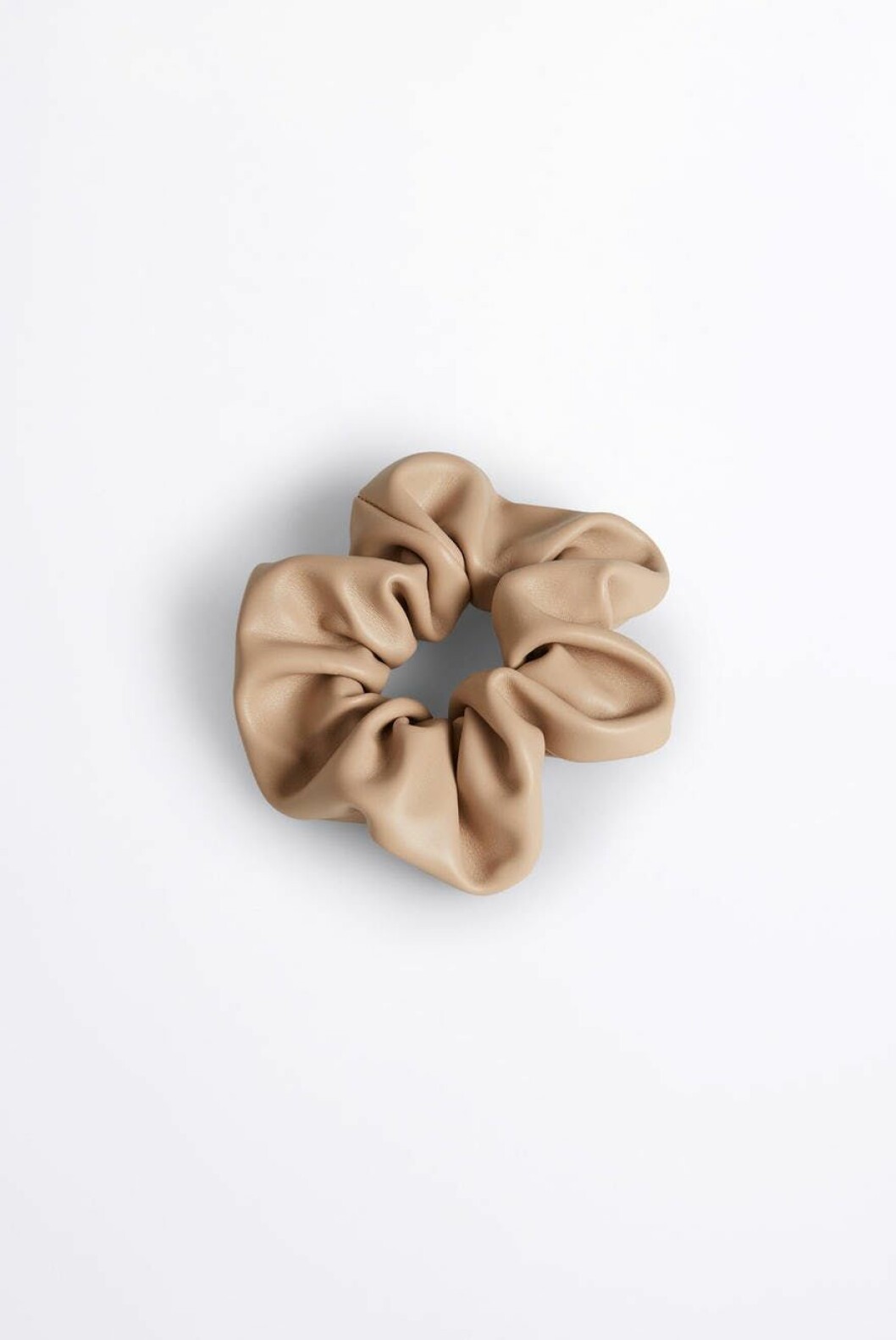 Piffa hårsvansen med en snygg snodd som denna i beige skinnimitation från Gina tricot.