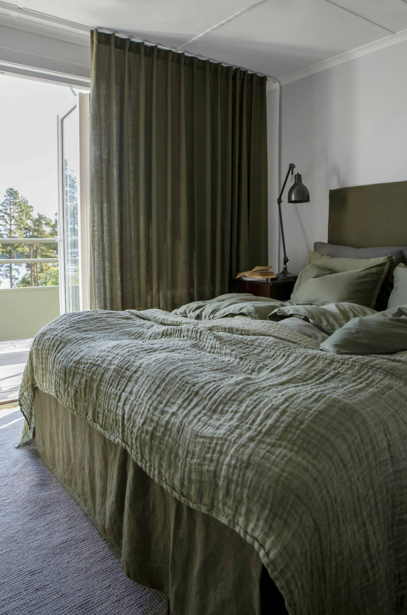 mysigt sovrum med bäddad säng och gardiner