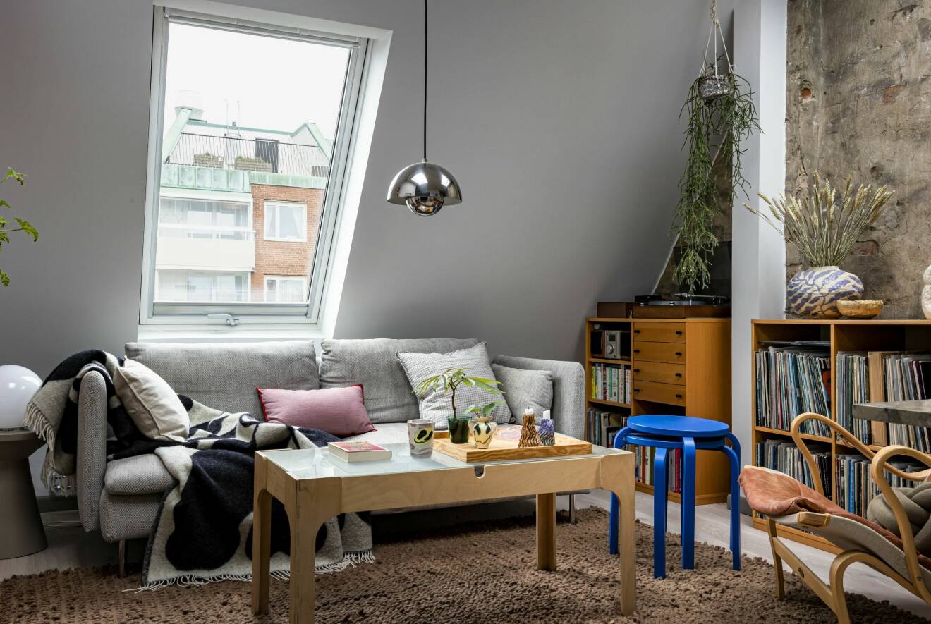Ombonat vardagsrum i vindsvåningen med Bruno Mathson-fåtölj, Ikea-soffbord.