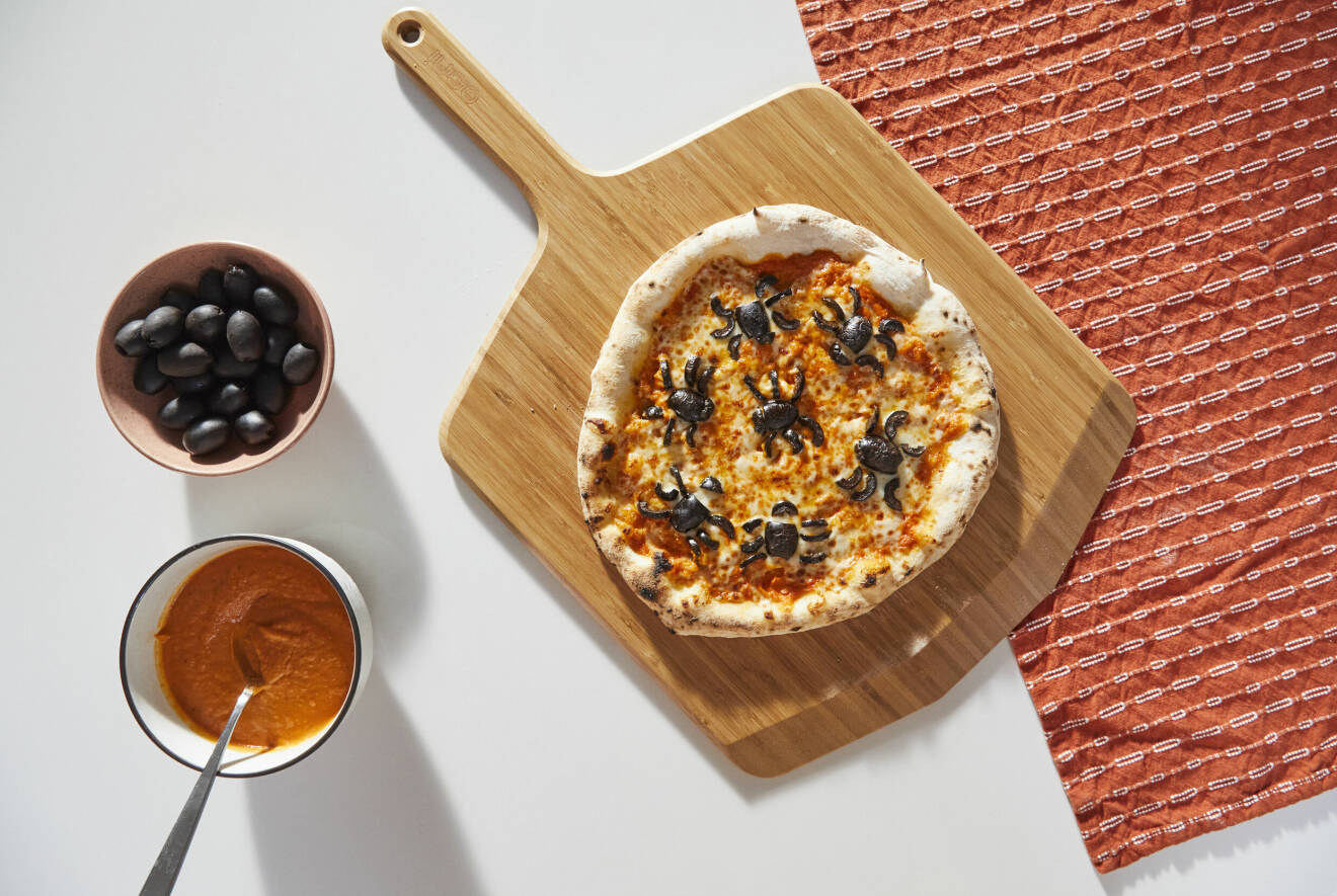 Dekorera pizzan med olivspindlar, det blir skrämmande gott