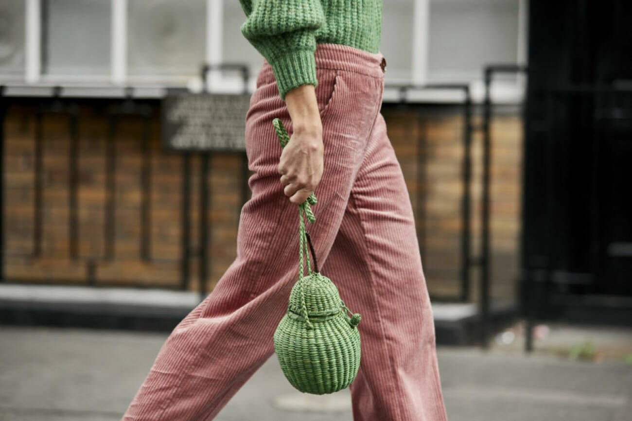 Grön korgväska i kombination med rosa byxor. 