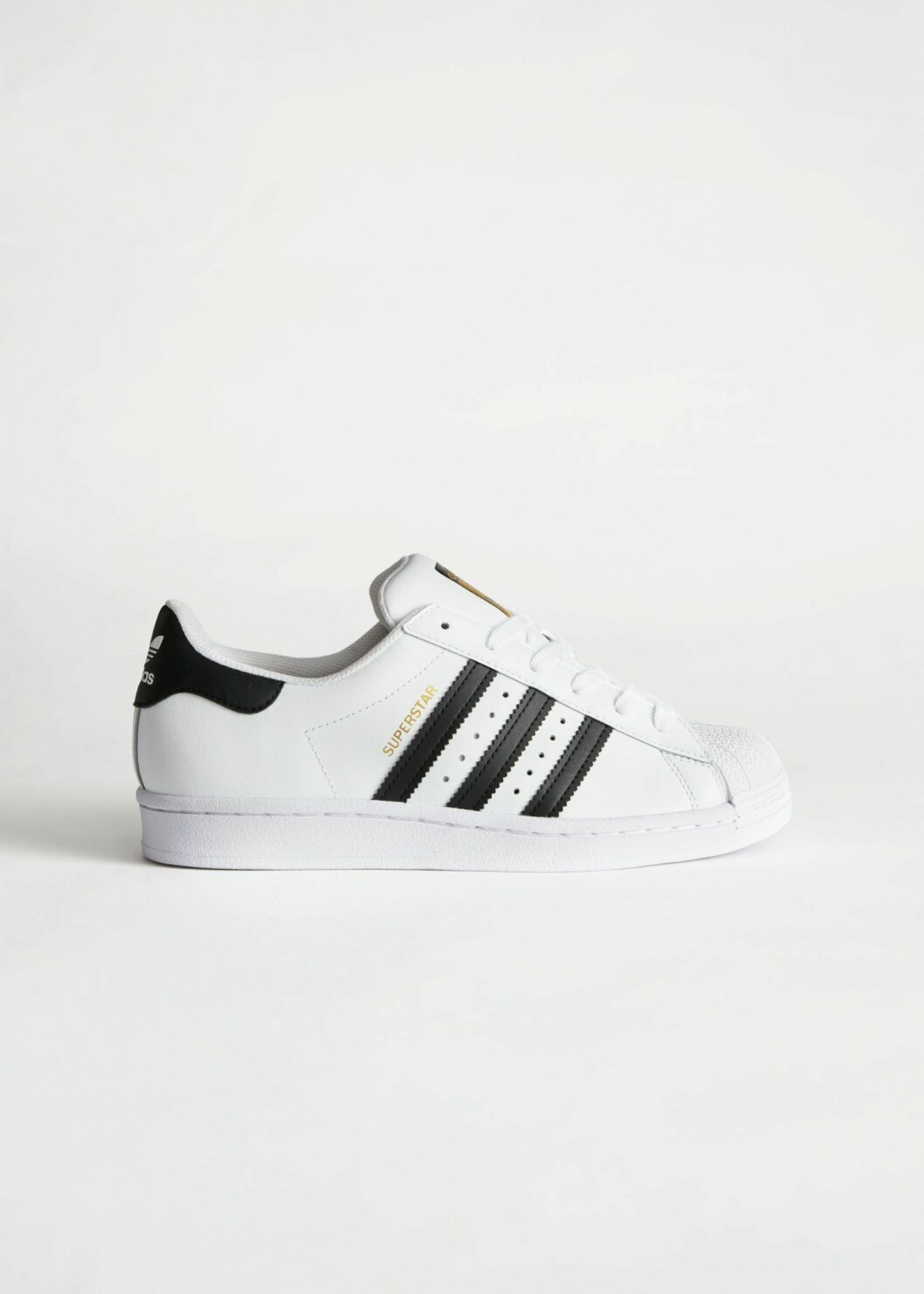 Vita sneakers med detaljer i svart från Adidas.