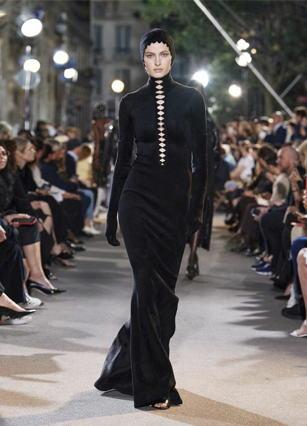 Alaia SS22 visar det klassiskt svarta från topp till tå – och toppar med dekorativa cut-outs! Alaias vårkollektion SS22, svart figurnära klänning med små cut outs.