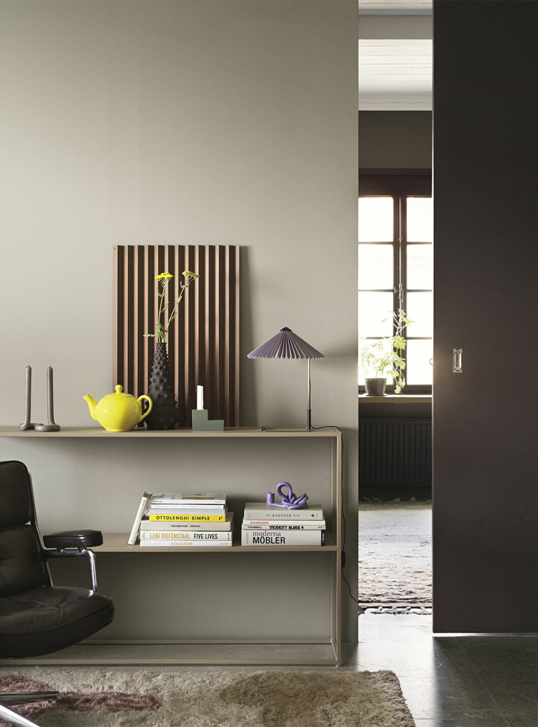Både lavendel och gult går fint att kombinera med beige och andra jordnära neutraler. Vägg målad i <em>001 Stråhatt</em>, lampskärmen i <em>003 Stjärnanis</em> och dörren i <em>008 Juniperus</em>. Foto: Alcro Lavendel och gult hos Alcro 2021