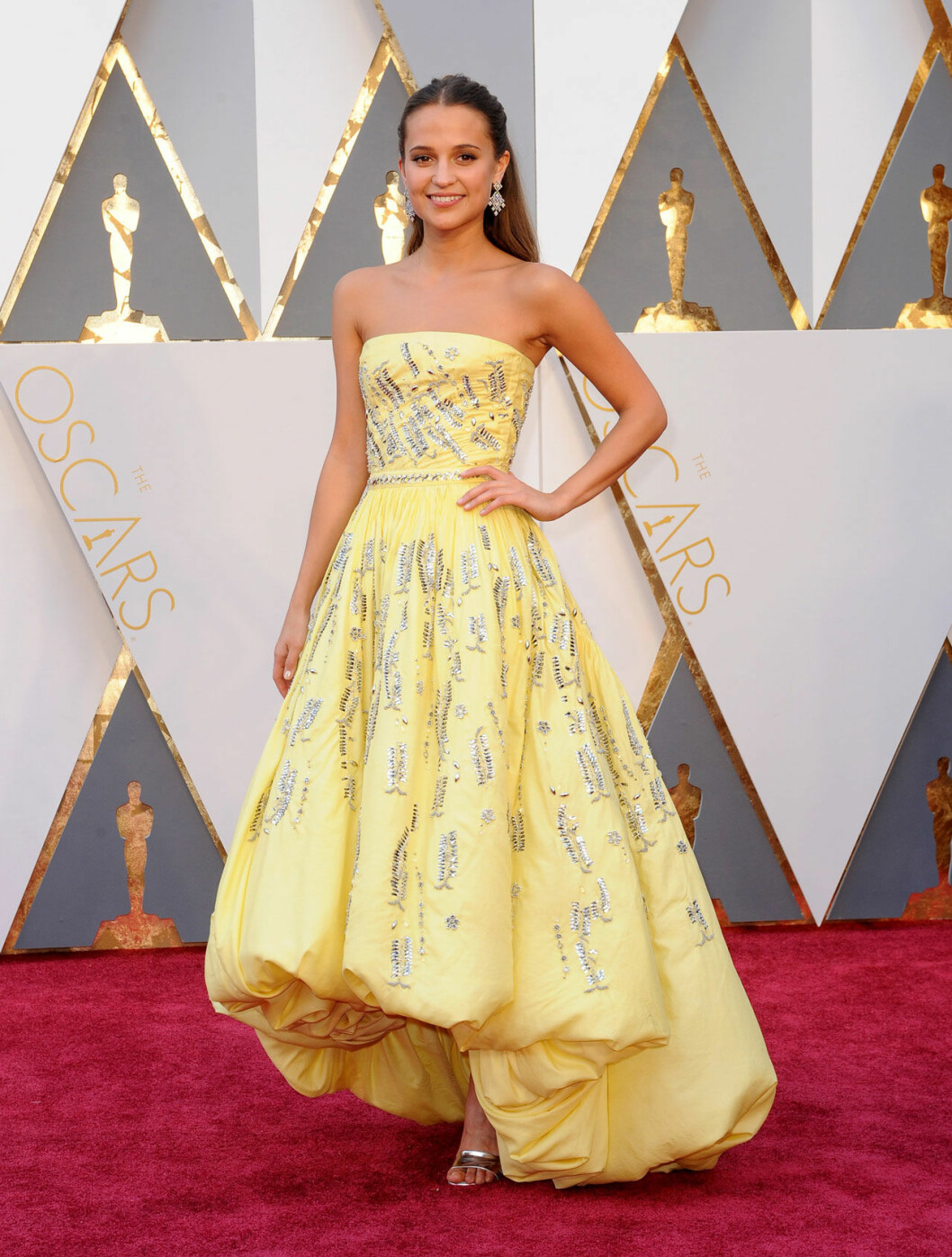 Alicia Vikander på Oscarsgalan 2016 – samma år som som hon vann pris i kategorin bästa kvinnliga biroll. Alicia Vikander i en gul klänning