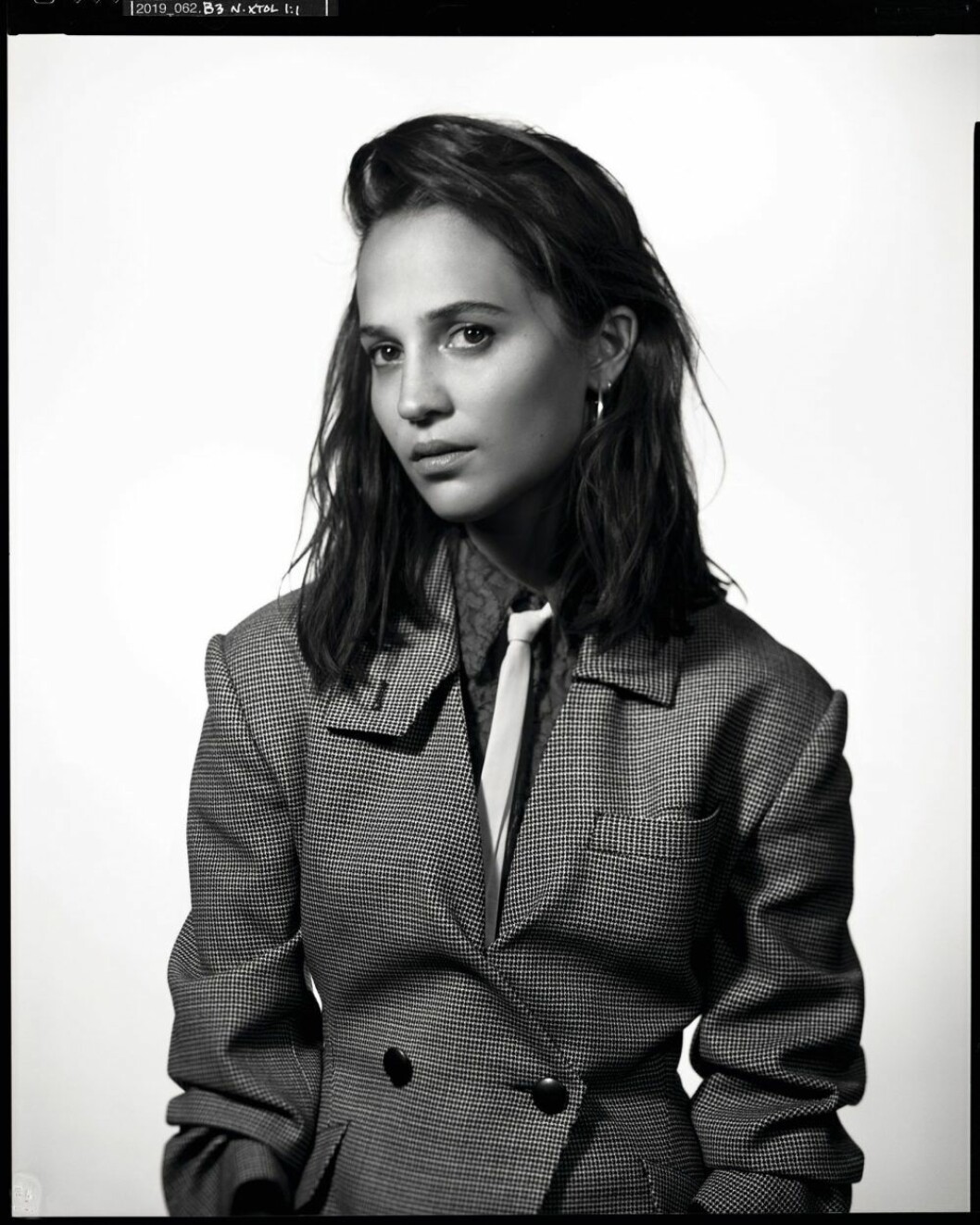 Ulljacka, klänning i bomullsspets och läderslips, allt Louis Vuitton. Örhängen, Charlotte Chesnais. Alicia Vikander i ulljacka från Louis Vuitton