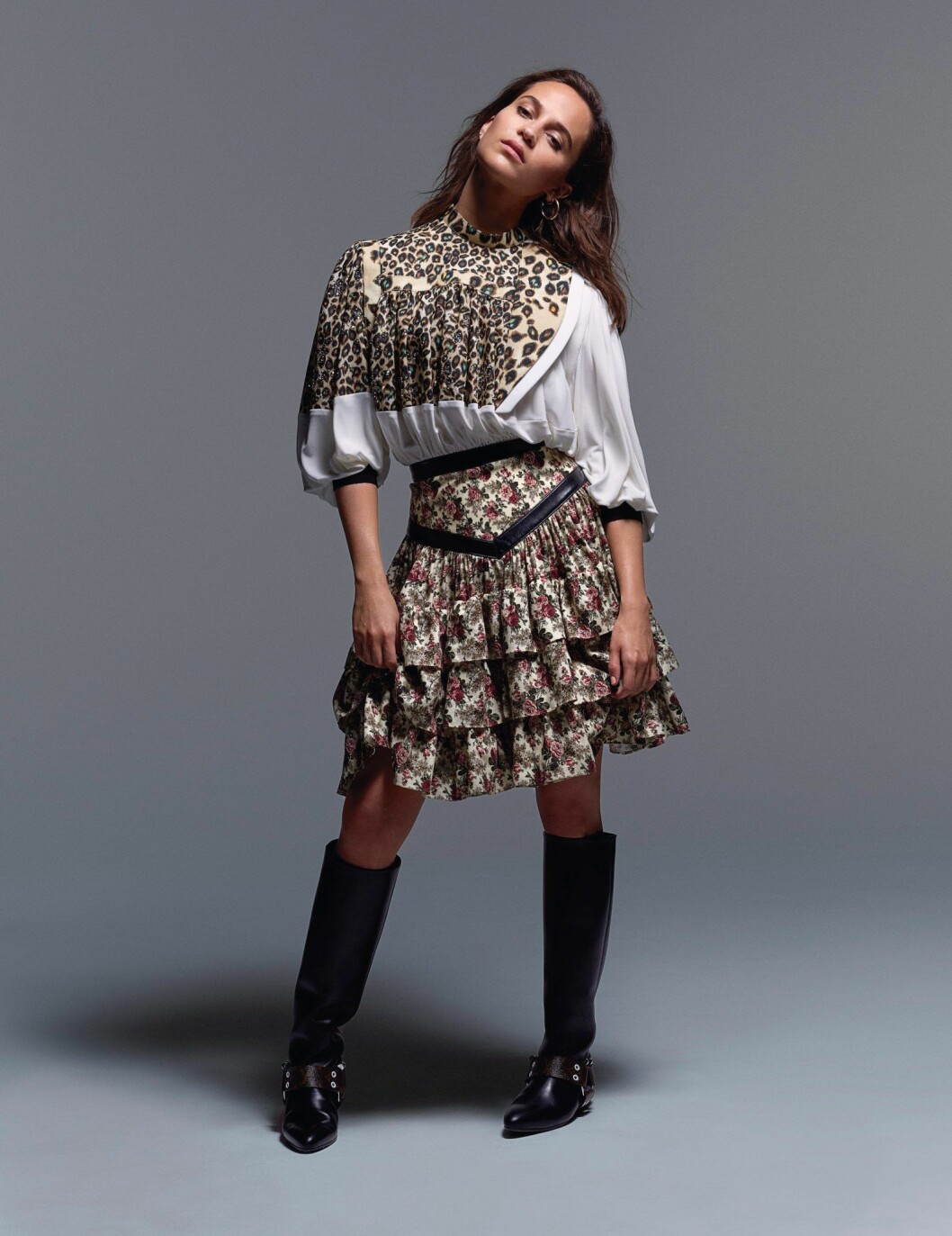 Blus, kjol och stövlar, allt Louis Vuitton. Örhängen, Charlotte Chesnais. Alicia Vikander i mönstrad blus och kjol från Louis Vuitton