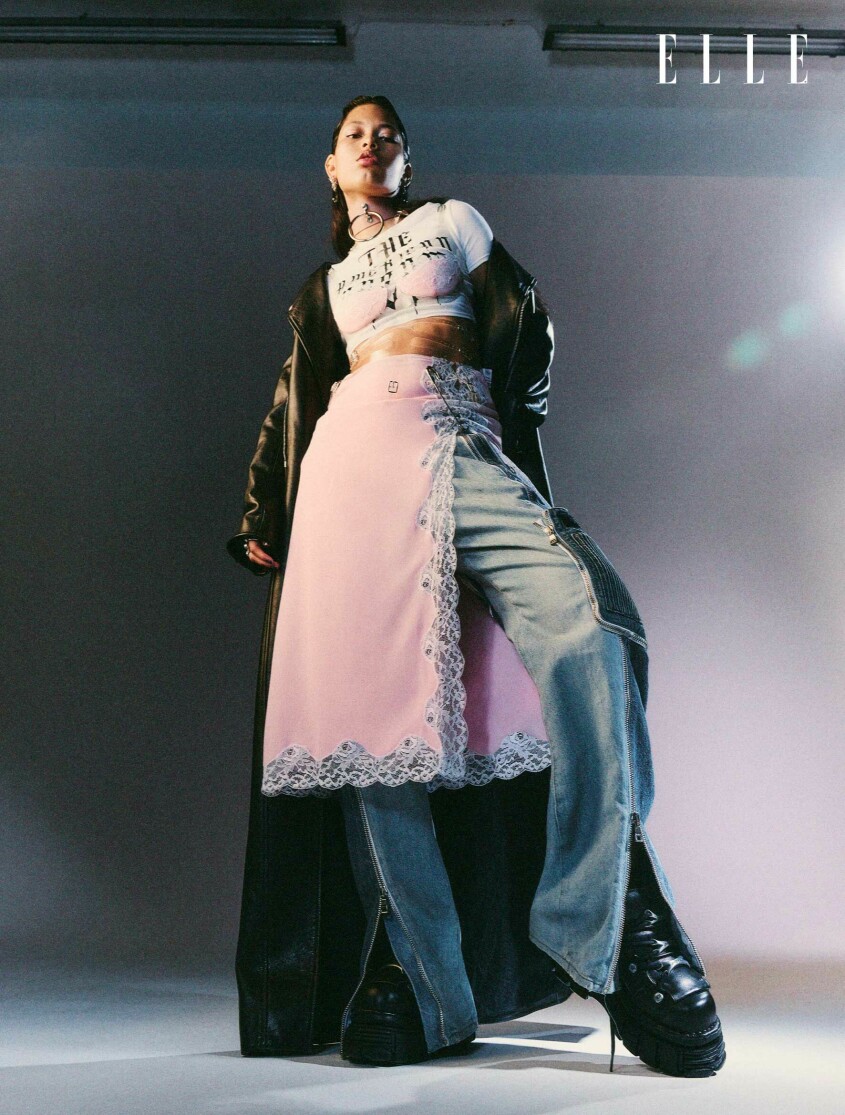 Kappa, 49 450 kr, Ann Demeulemeester. Klänning, pris vid beställning, Christopher Kane. T-shirt, 925 kr, Laruicci. Jeans, 10 800 kr, Balmain. Skor, 2 999 kr, New Rock/Sko Uno. Choker, 1 700 kr, Zana Bayne. Säkerhetsnål, Archive by Ann-Sofie Back. Hängande örhängen i vardera öra, 800 kr, Pretty Ugly. Spjutformat örhänge, 895 kr, och örhänge med nitar, 4 875 kr, båda Pantolin. Ring på långfinger, pris vid beställning, Cartier. Ring på pekfinger, pris vid beställning, Sportmax. Modellen har på sig en lång svart kappa, klänning i rosa och ljusa jeans.